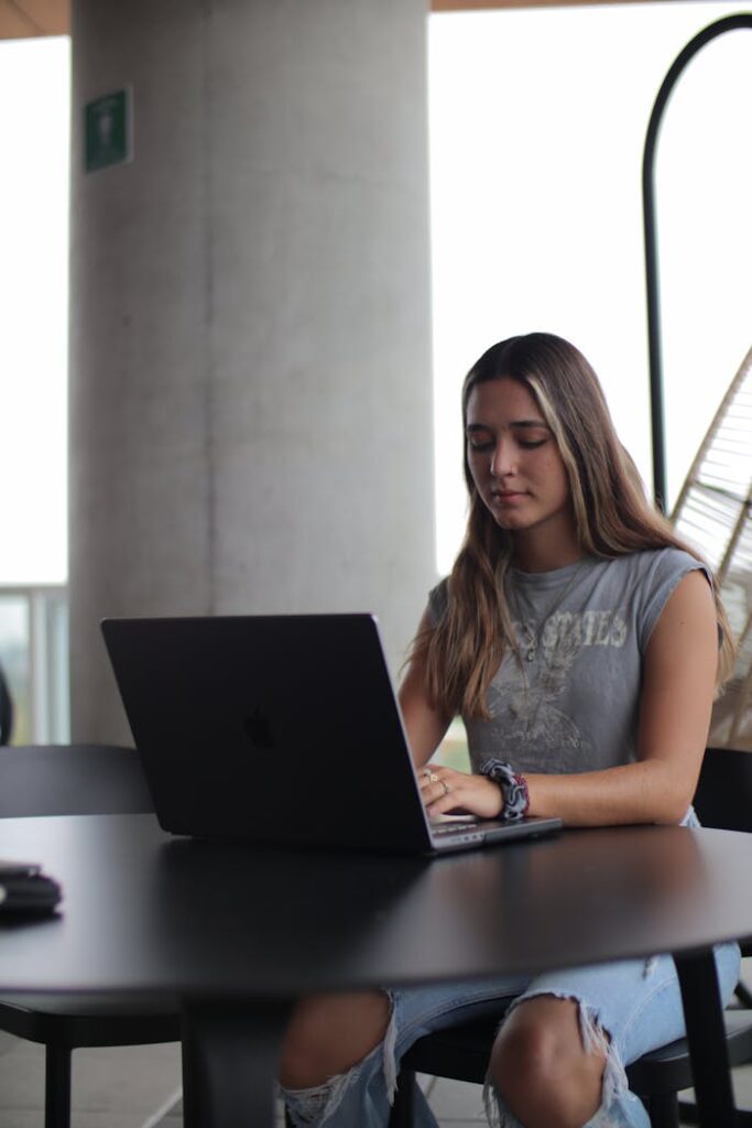 A woman sitting at a table with a laptop